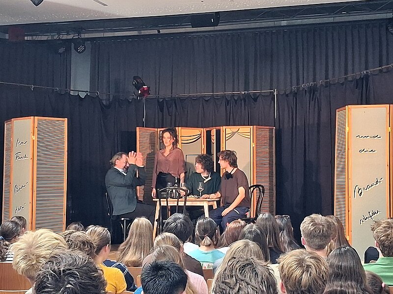 Theateraufführung mit Schauspielern und Publikum in einem Schulsaal