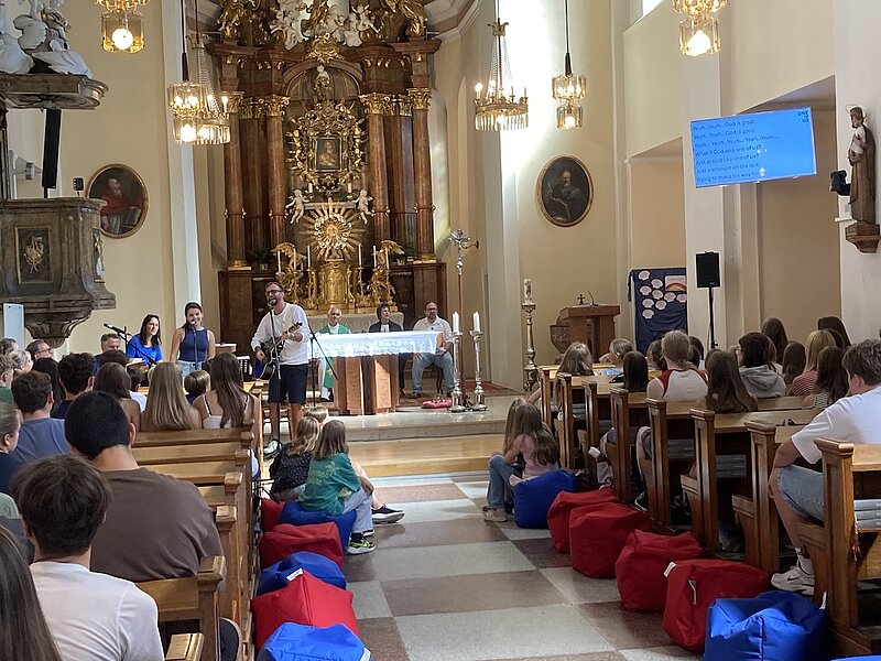 Jugendliche bei Gottesdienst in Kirche mit Gitarre und Gesang