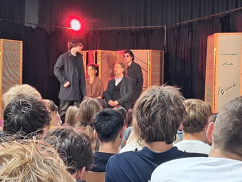 Schauspieler auf Bühne in Wien, Ensemblemitglieder vor Publikum bei Aufführung.