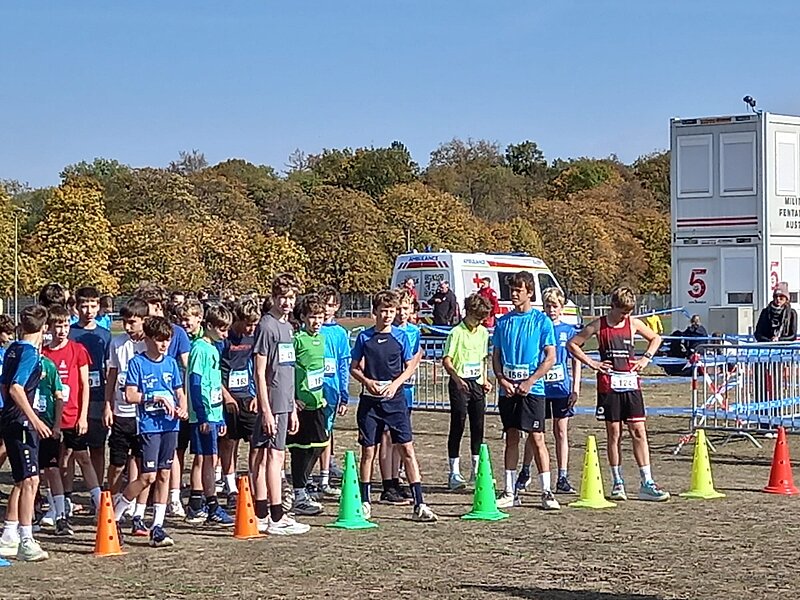 Jugendlauf: Läufer in Sportkleidung stehen am Start, im Hintergrund ein Rettungswagen und Container.